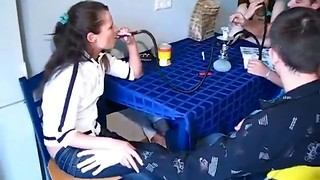 Two young chicks are sucking two cocks in the kitchen